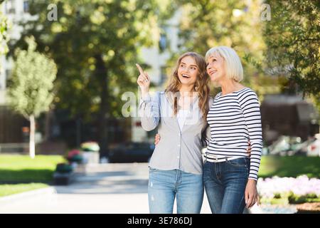 Liebende Tochter, die ältere Mutter für einen Spaziergang im Freien mitnimmt Stockfoto