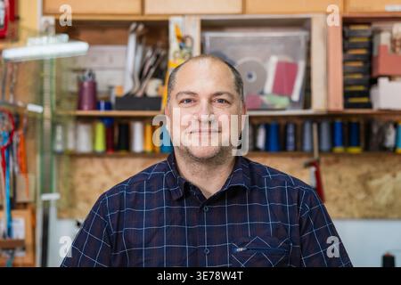 Männlicher Handwerker lächelt in seiner Werkstatt Stockfoto