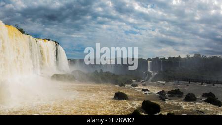 Die herrlichen Iguazu-Wasserfälle brüllen mit voller Kraft, wie sie von der brasilianischen Seite aus in Foz do Iguacu, Paraná, mit turbulentem, braun gefärbtem Wasser in Schwung treten Stockfoto