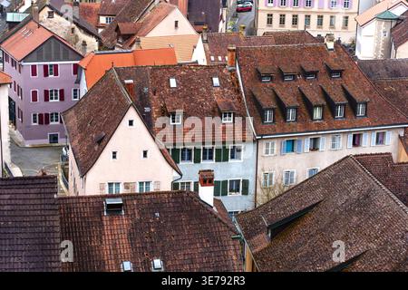 Bezaubernde historische Dächer und farbenfrohe Fassaden in der Altstadt von Porrentruy, Schweiz, mit traditionellen Terrakottafliesen und Holzläden Stockfoto
