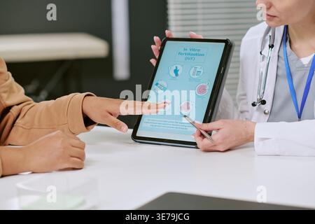 Ärztin erklärt die IVF-Behandlung mit Tablette während der Konsultation Stockfoto