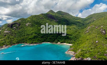 Eine abgeschiedene Bucht mit Strand, umgeben von dichtem tropischem Wald. Anse Major. Seychellen, Mahe. Stockfoto