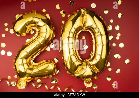 Herzlichen Glückwunsch zum Geburtstag. 20 Jahre alt. Goldballons Nummer 20 auf rotem Hintergrund mit Konfetti, 20 Jahrestag. Kopierbereich Stockfoto