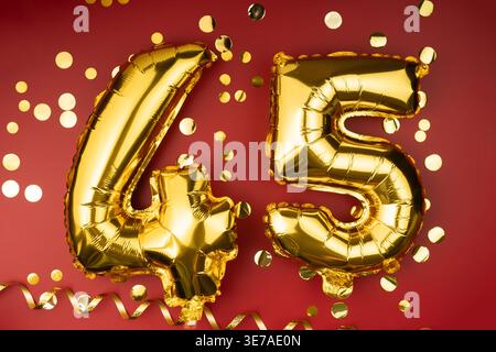 45. Geburtstag. Goldene festliche Ballons Zahl 45-jähriges Jubiläum auf rotem Hintergrund mit Konfetti. Geburtstag oder Hochzeit. Stockfoto