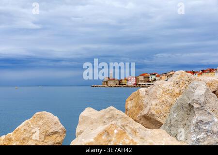 Große Felsen im Vordergrund mit Piran Altstadt und Adria im Hintergrund. Stockfoto