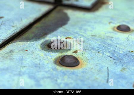 Nahaufnahme der veralteten Metalloberfläche mit Rost und Schrauben. Hintergrund der industriellen Textur. Stockfoto