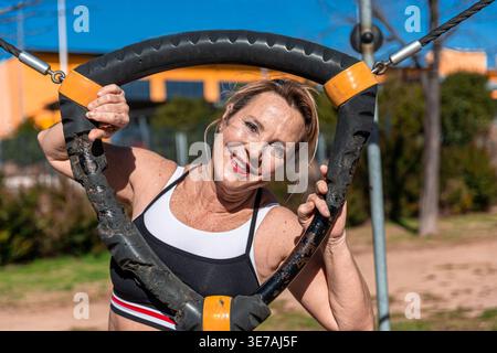 Ältere Frau lächelt beim Fitness-Training im Freien Stockfoto