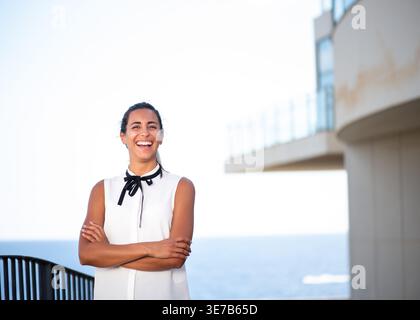 Porträt lächelnde junge Geschäftsfrau, die draußen mit Kunst steht Stockfoto