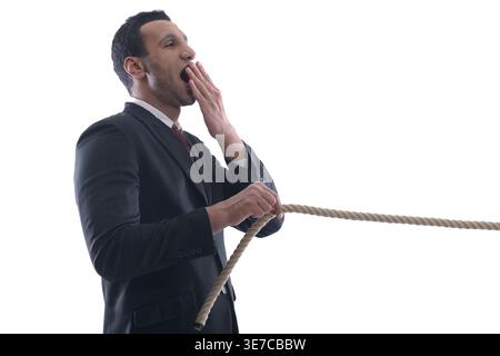 Geschäftsmann aus dem Nahen Osten zieht Seil auf weißem Hintergrund im Studio Stockfoto