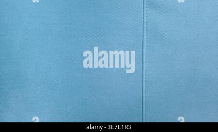 Minimalistischer hellblauer Texturhintergrund mit weicher Textilstruktur und dezenter Nahtdetail. Klarer abstrakter Hintergrund, geeignet für Design und Branding Stockfoto
