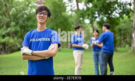 Lächelnder asiatischer Mann, der tagsüber in der Nähe des Teams steht Stockfoto