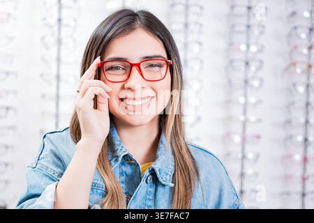 Nicaraguanische Kundin in Jeansjacke mit Brille im optischen Geschäft Stockfoto