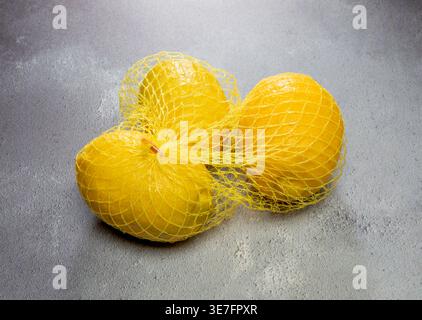 Zitronen in Netzverpackungen. Stockfoto