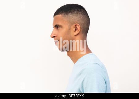 Ernster arabischer männlicher Teenager, der seitlich vor weißem Hintergrund wegschaut Stockfoto