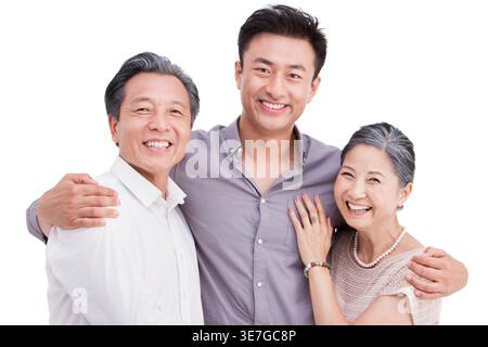 Ein lächelnder chinesischer Mann umarmt seine älteren Eltern, während er vor weißem Hintergrund im Studio steht Stockfoto