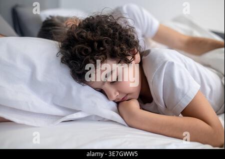 Arabischer Junge, der friedlich mit seinem Vater zu Hause im Bett schläft Stockfoto