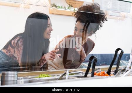 Zwei glückliche Freunde entscheiden sich für das Essen im Restaurant Stockfoto