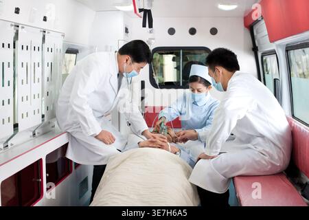 Chinesische Ärzte behandeln einen Patienten im Krankenwagen Stockfoto
