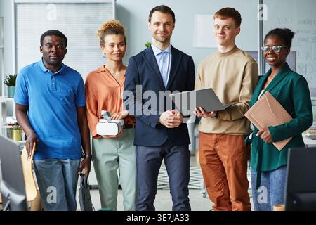 Verschiedene Gruppen von Programmierern, die im Büro eng zusammenstehen Stockfoto
