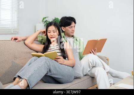 Thailändisches Paar liest Bücher auf Sofa zu Hause Stockfoto