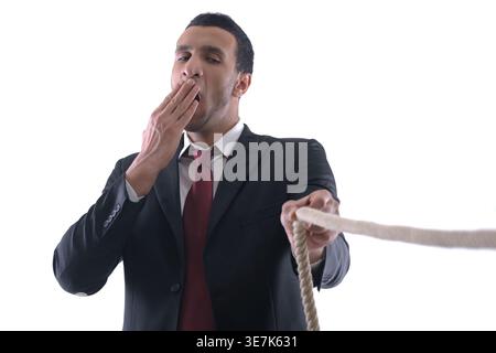 Geschäftsmann aus dem Nahen Osten zieht Seil auf weißem Hintergrund im Studio Stockfoto