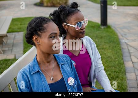 Schwarze Frauen mit Abstimmknopf und Sonnenbrille mit amerikanischer Flagge Stockfoto