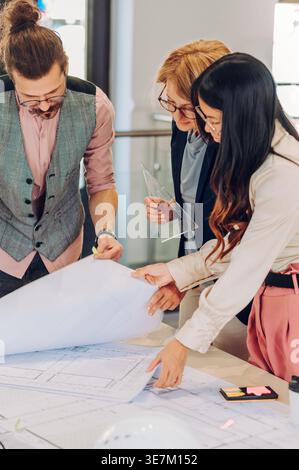 Nahaufnahme einer Gruppe von Architekten, die im Büro an Bauplänen arbeiten Stockfoto