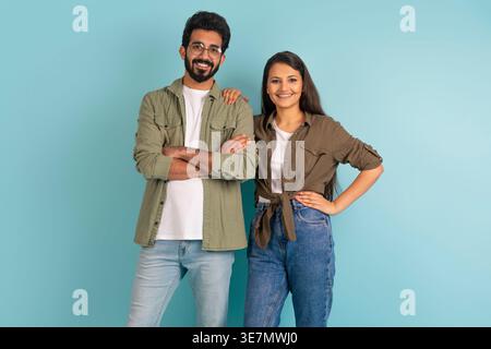 Lächelndes asiatisches Paar, das vor blauem Hintergrund im Studio steht Stockfoto