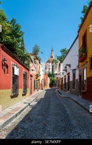 Straßen der alten mexikanischen Stadt San Miguel, mit der berühmten rosa Kirche in der Ferne. Stockfoto