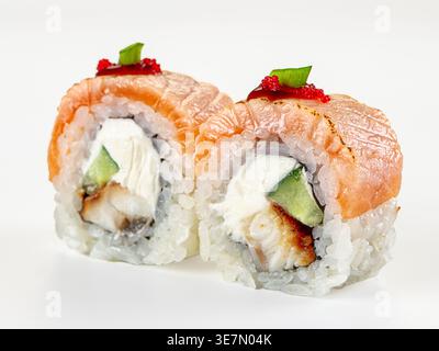 Eine Nahaufnahme von zwei japanischen Uramaki-Sushi-Brötchen mit gebratenem Lachs, Aal, Frischkäse, Gurke. Garniert mit rotem Tobiko-Reh. Saubere, minimalistische Komposition Stockfoto