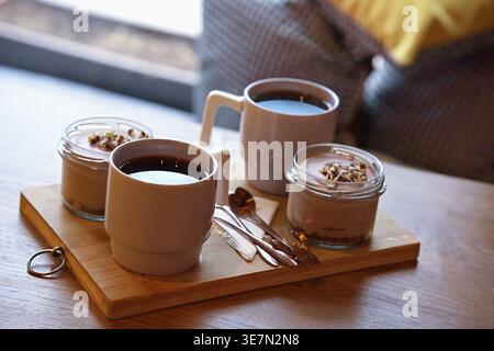 Tisch mit Desserts und Getränken auf einem Holzbrett in einem gemütlichen Café. Horizontales Foto Stockfoto