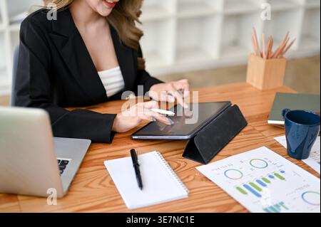 Asiatische Geschäftsfrau, die ein Tablet am Schreibtisch im Büro benutzt Stockfoto