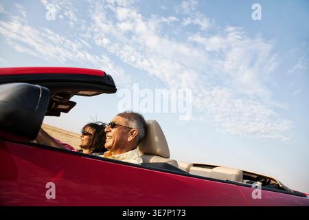 Senior Hispanic Paar fährt Cabriolet und fährt im Sommer auf Roadtrip Stockfoto