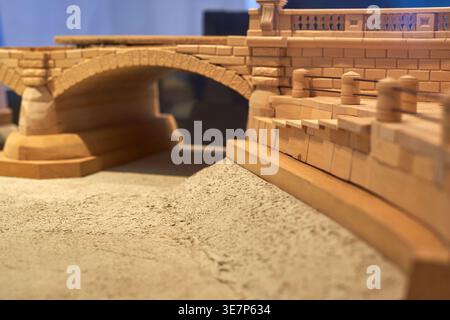 Nahaufnahme eines kunstvollen hölzernen Architekturmodells einer historischen Steinbrücke. Die detaillierte Handwerkskunst zeigt einzelne Holzblöcke Stockfoto
