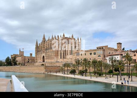 Mallorca. Spanien - 11. April 2026: Großer Blick auf die Kathedrale Santa Maria von Palma und den Almudaina Palast mit Blick auf den ruhigen Salzwassersee von Parc Stockfoto