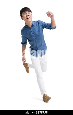 Chinesischer Mann, der vor weißem Hintergrund im Studio läuft Stockfoto
