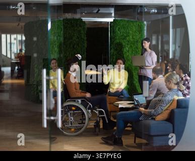 Verschiedene Gruppen von Geschäftsleuten mit Behinderungen kaukasischer Geschäftsmann, die VR-Brillen und Drohnenhilfesimulationen während eines Meetings im... Stockfoto