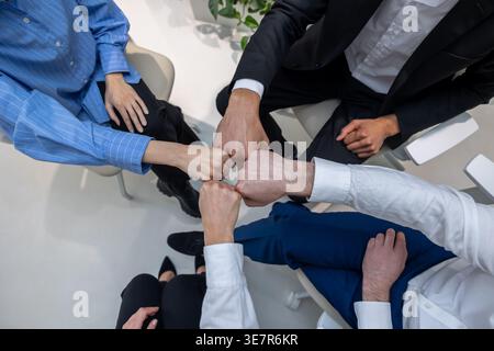 Schwarzer Mann mit kaukasischen Kollegen, die während der Psychotherapiesitzung auf Stühlen sitzen Stockfoto