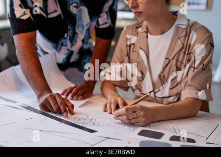 Gemischte Architekten arbeiten gemeinsam an Grundrissen und Farbauswahl für Innenarchitektur-Projekte im Büro Stockfoto