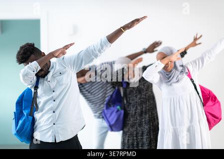 Schwarze und muslimische Studenten, die im Studio mit Rucksäcken vor der weißen Wand stehen Stockfoto