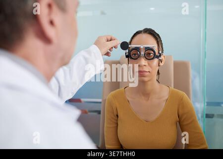 Schwarze Frau sitzt und hört dem Arzt in der Klinik zu Stockfoto