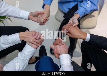 Schwarzer Mann mit kaukasischen Kollegen, die während der Psychotherapiesitzung im Kreis auf Stühlen sitzen Stockfoto