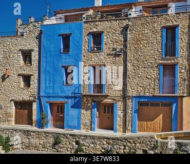 Traditionelle Steinhäuser mit hellblau bemalten Abschnitten und Holztüren an einem sonnigen Tag in der katalonischen Stadt San Mateu, Spanien Stockfoto
