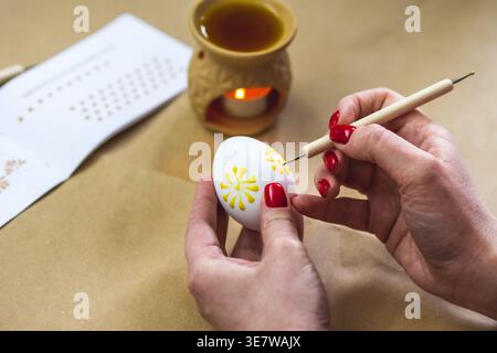 Litauisches Mädchen malt traditionelle Ostereier mit heißem Bienenwachs mit einer Nadel Stockfoto