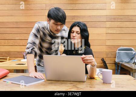 Multiethnische Paare mit Laptop im Büro Stockfoto