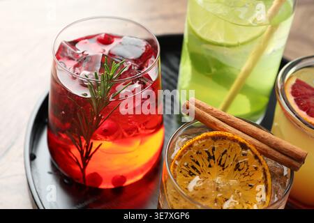 Verschiedene leckere erfrischende Cocktails in Gläsern auf dem Tisch, Nahaufnahme Stockfoto