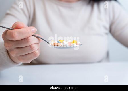 Person, die einen Löffel voller Pillen hält, Konzept der Überdosierung und gefährlicher Drogenkonsum Stockfoto
