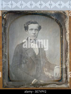 Ein altmodisches Daguerreotypisches Porträt zeigt einen jungen Mann aus der viktorianischen Zeit in formeller Kleidung und hebt frühe fotografische Techniken hervor Stockfoto