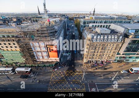 Die geschäftige Princes Street in Edinburgh, Schottland, mit Gebäuden unter Gerüsten und einer prominenten Werbung für das IPH Stockfoto