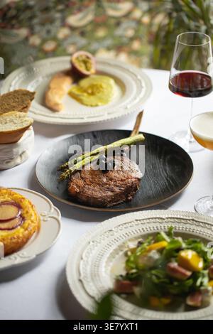 Steakabendessen mit Spargel und Wein auf dem Tisch Stockfoto